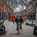 Statues of firefighters in Seattle's Pioneer Square with a fire engine parked in the background