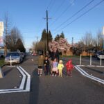 A dad with a group of five children smile for a photo on a Healthy Street