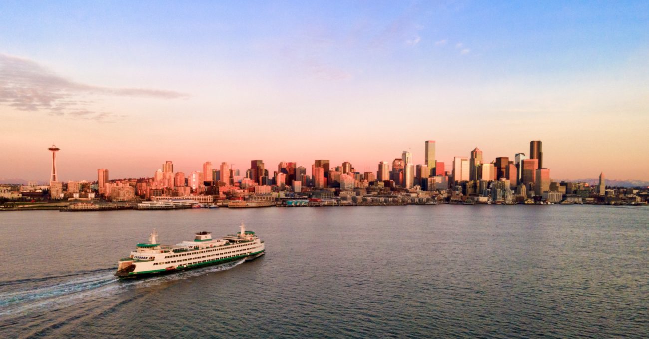 A ferry sailing towards downtown Seattle at sunset